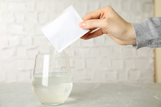 pouring cbd powder in glass of water